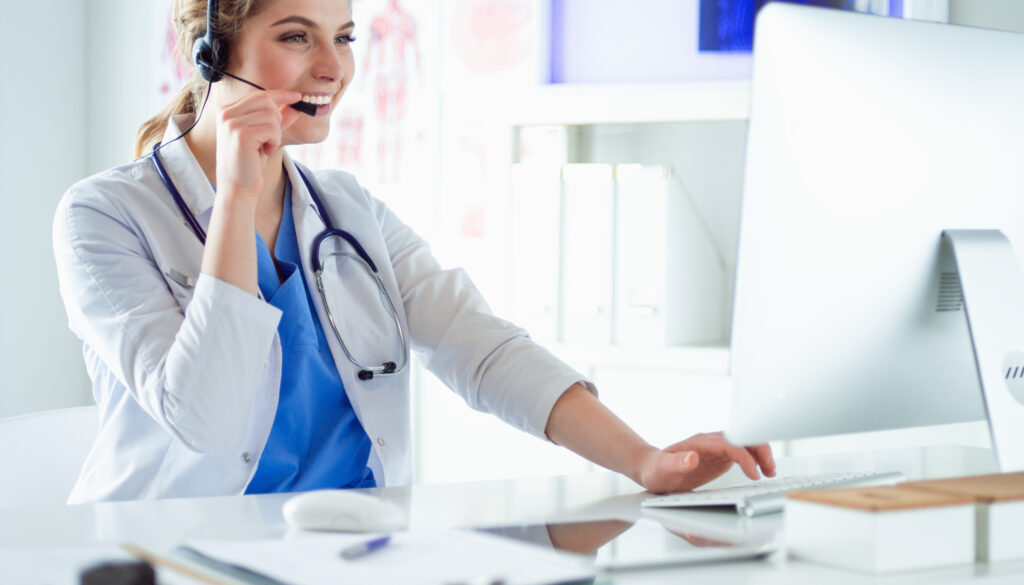 Young practitioner doctor working at the clinic reception desk, she is answering phone calls and scheduling appointments. Questions About CareXM