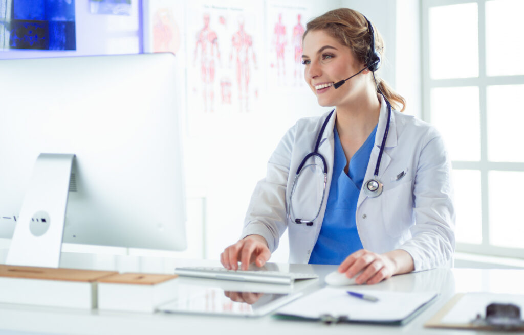 Young practitioner doctor working at the clinic reception desk, she is answering phone calls and scheduling appointments. Triage Nursing Skill