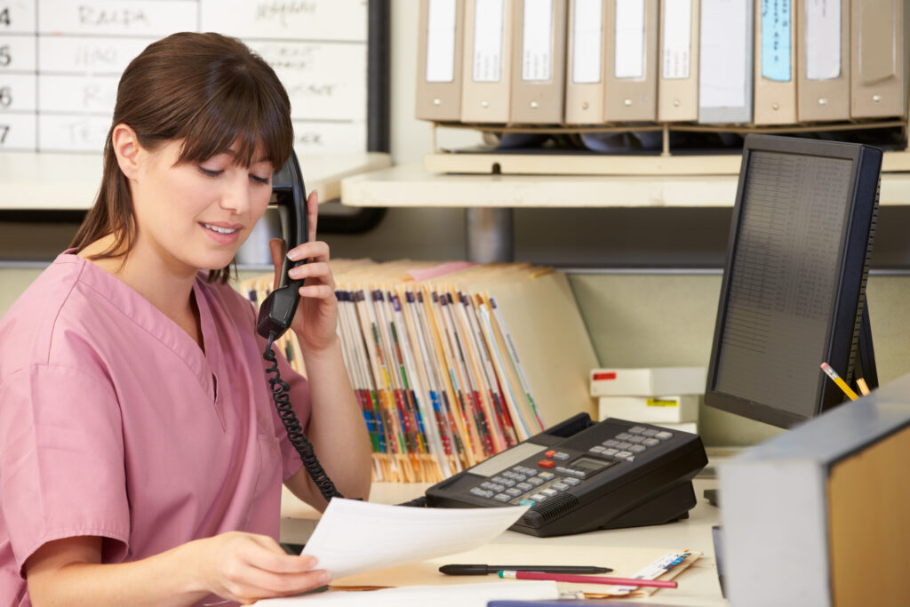 Nurse Making Phone Call At Nurses Station. Triage Nursing Skill. Triage Nursing Skill