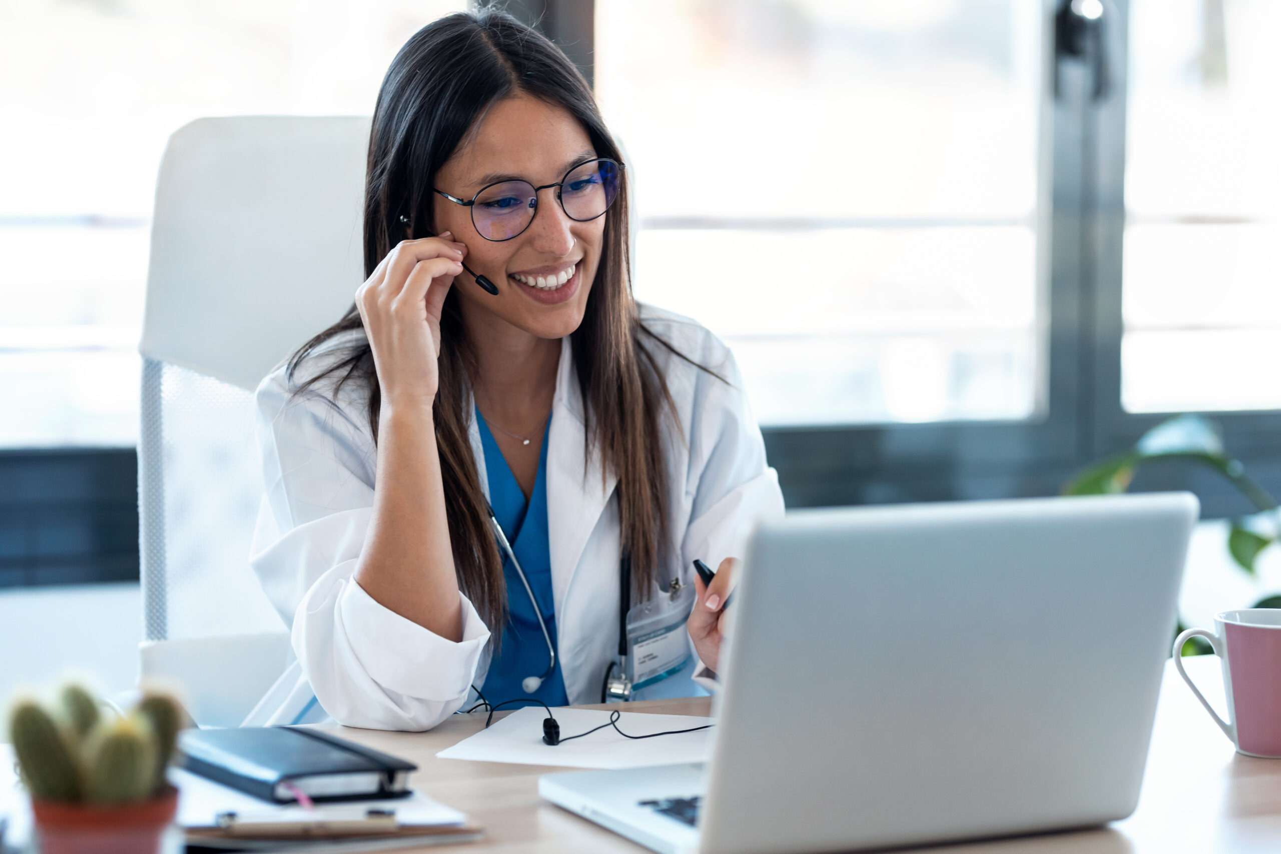 Female doctor talking with colleagues through a video call with